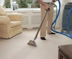 Carpet cleaning professional removing dirt and stains with a hot-water extraction tool in a home, Los Angeles, CA.