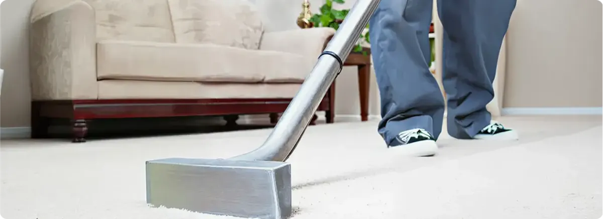 Carpet cleaning technician using a hot-water extraction wand on a light-colored carpet in a living room, Los Angeles, CA.